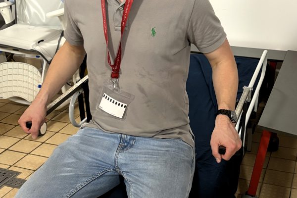 REMAP engineer sitting on a changing bed demonstrating how it is used